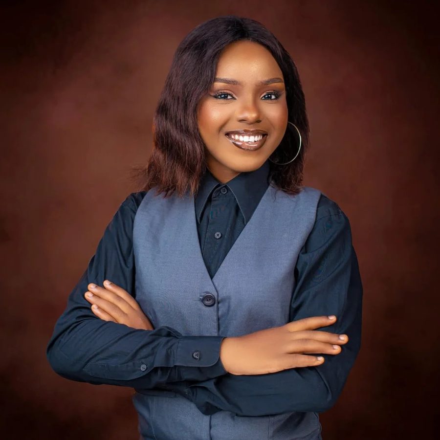 Portrait of Comfort Alugo Onwe, smiling with arms crossed